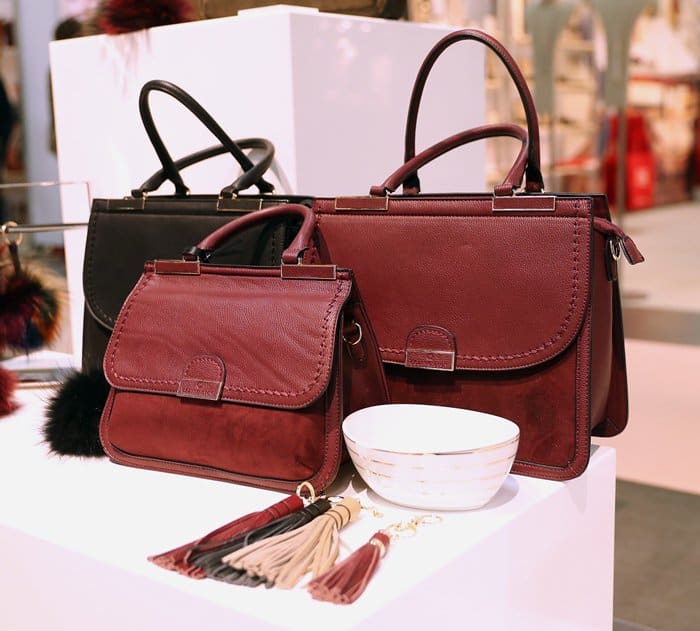 A collection of structured satchels and top-handle bags in burgundy and black