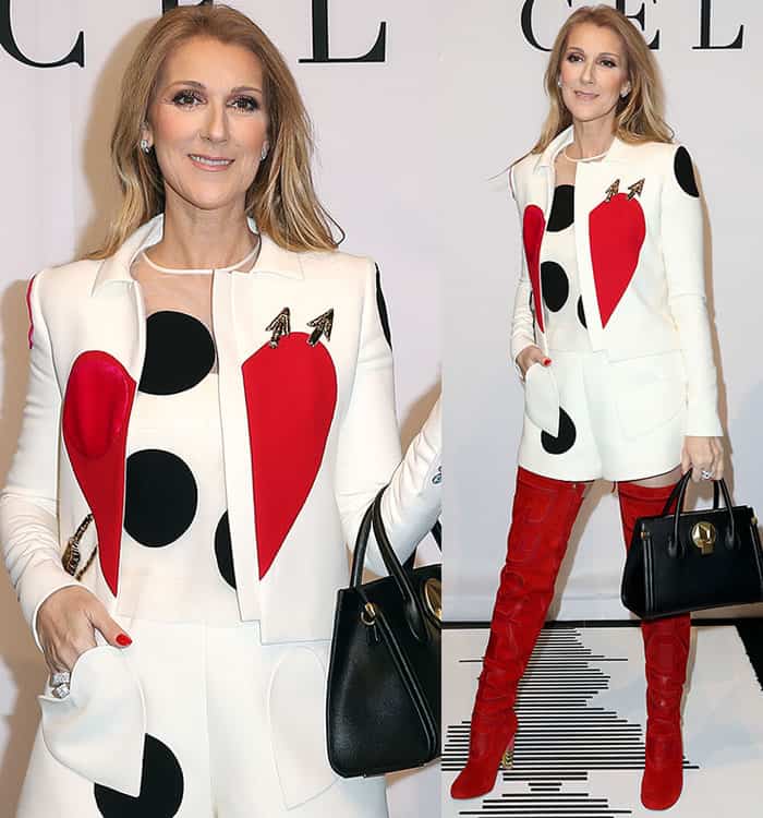 Carrying one of her debut handbags, Dion balances sharp tailoring and playful motifs while the vivid red boots ground the look with authority