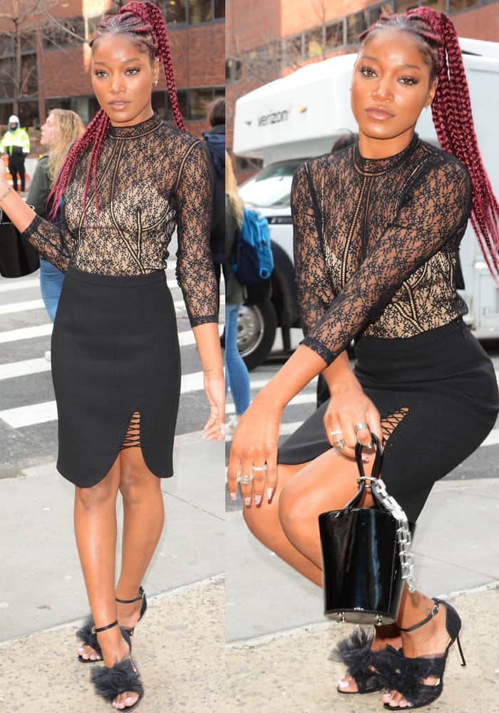 Keke Palmer pairs her black lace Alexander Wang top and lace-up slit skirt with Isa Tapia’s feathery “Gigi” tulle sandals and a sleek black patent bucket bag for a sharp, monochrome street-style moment in New York