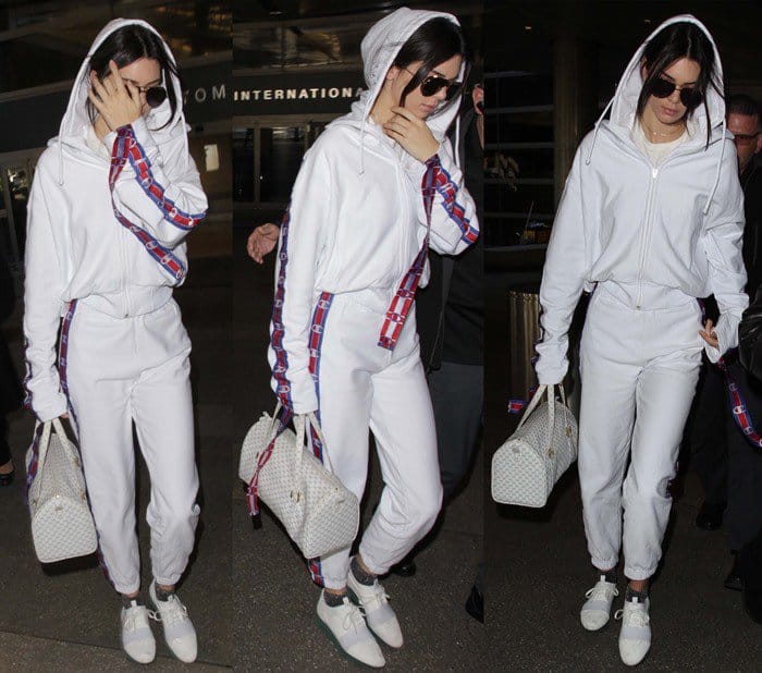 Kendall Jenner effortlessly combines comfort and style in a white Vetements tracksuit, accessorized with Balenciaga Race Runner sneakers and a chic Louis Vuitton bag