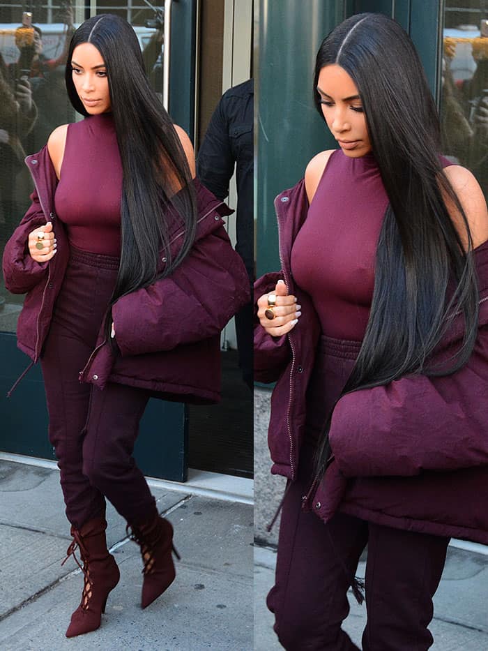 Kim Kardashian stuns in a monochromatic oxblood Yeezy ensemble, pairing pintucked sweatpants, a sleek bodysuit, and lace-up boots with a cozy puffer jacket