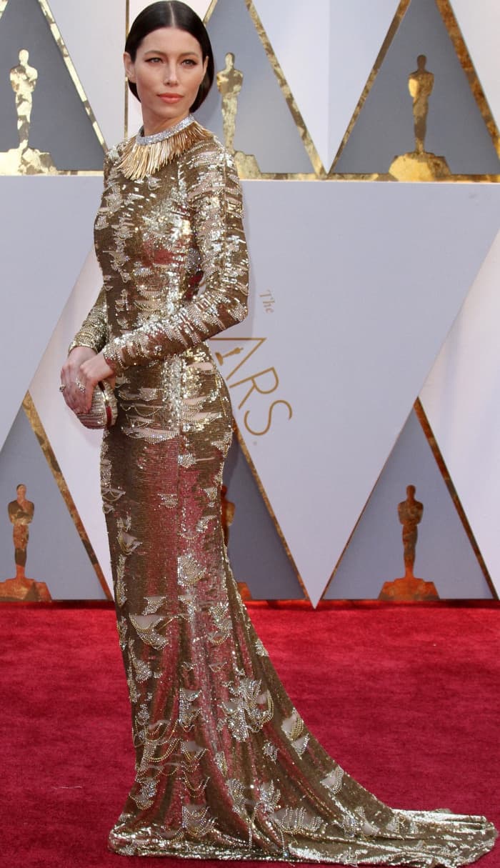 Jessica Biel stuns in a metallic KaufmanFranco gown with intricate silver sequin embellishments, styled with a bold Tiffany Co. necklace and a sleek updo for a refined red carpet look