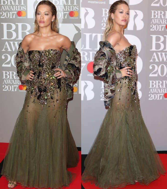 Rita Ora dazzles in a strapless Alexandre Vauthier gown adorned with intricate sequins and a sheer tulle skirt, paired with shimmering gold strappy heels that add a touch of elegance to her bold red carpet look