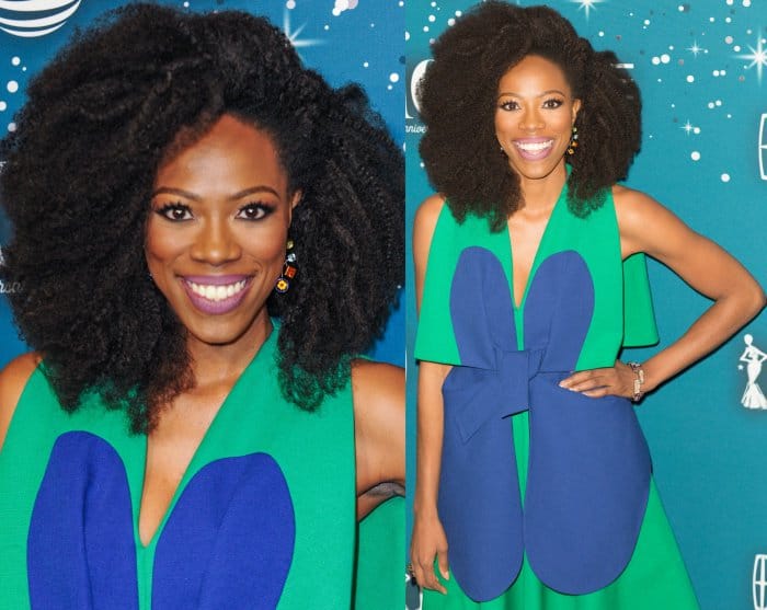 Yvonne Orji dazzles in a vibrant green and blue Delpozo dress with bold petal details and a playful bow, perfectly complementing her radiant smile and natural curls