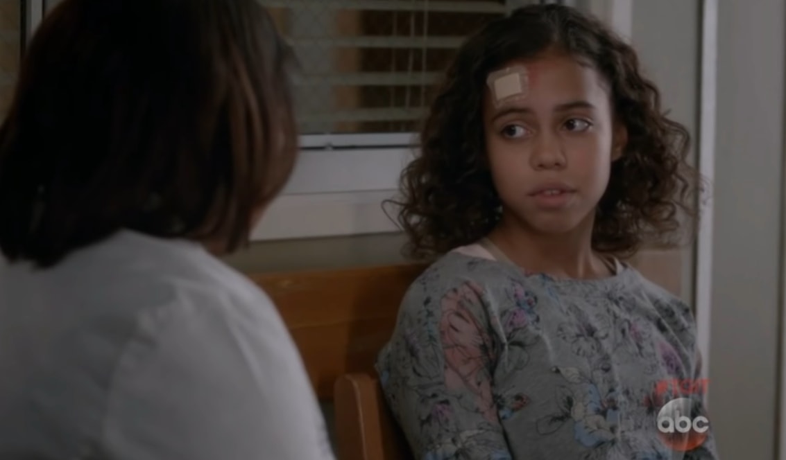 Asia Monet Ray appears as Jasmine Singh in Grey’s Anatomy Season 12, her soft floral top and natural curls underscoring the quiet vulnerability of the hospital scene