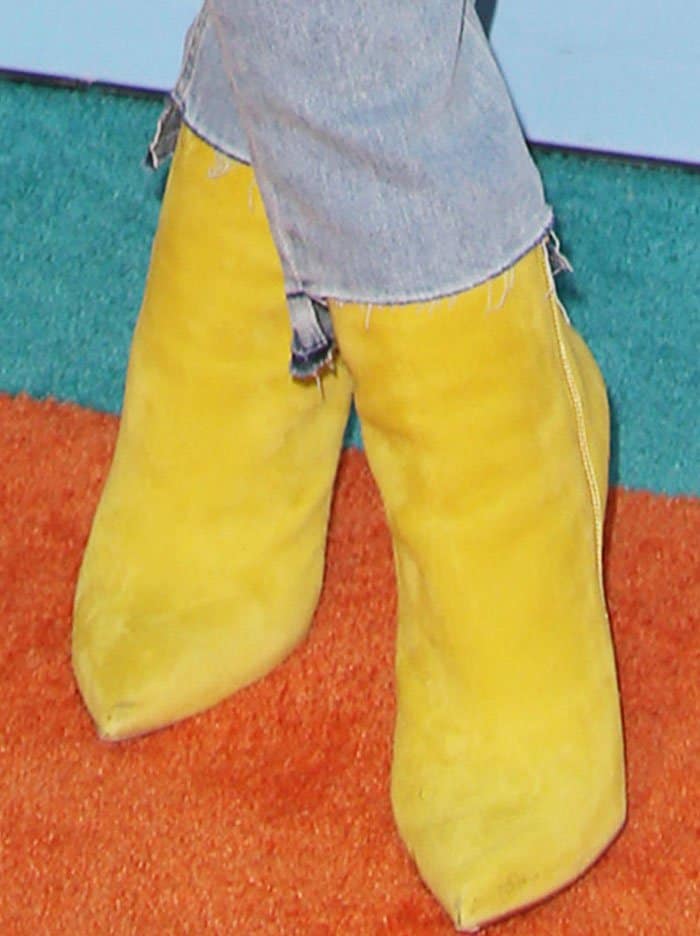 Blac Chyna wears mustard-yellow suede Christian Louboutin So Kate ankle boots with distressed jeans