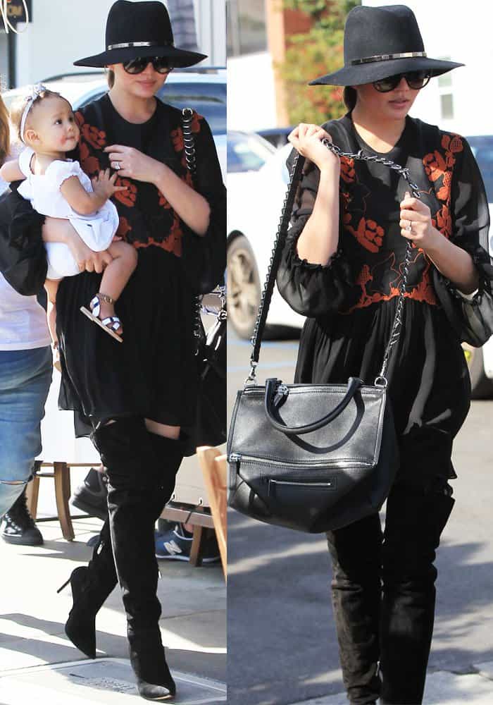 Chrissy Teigen exudes effortless chic in a black Chloé mini dress, Gianvito Rossi thigh-high boots, a Janessa Leone fedora, and a Givenchy Pandora tote while out with daughter Luna