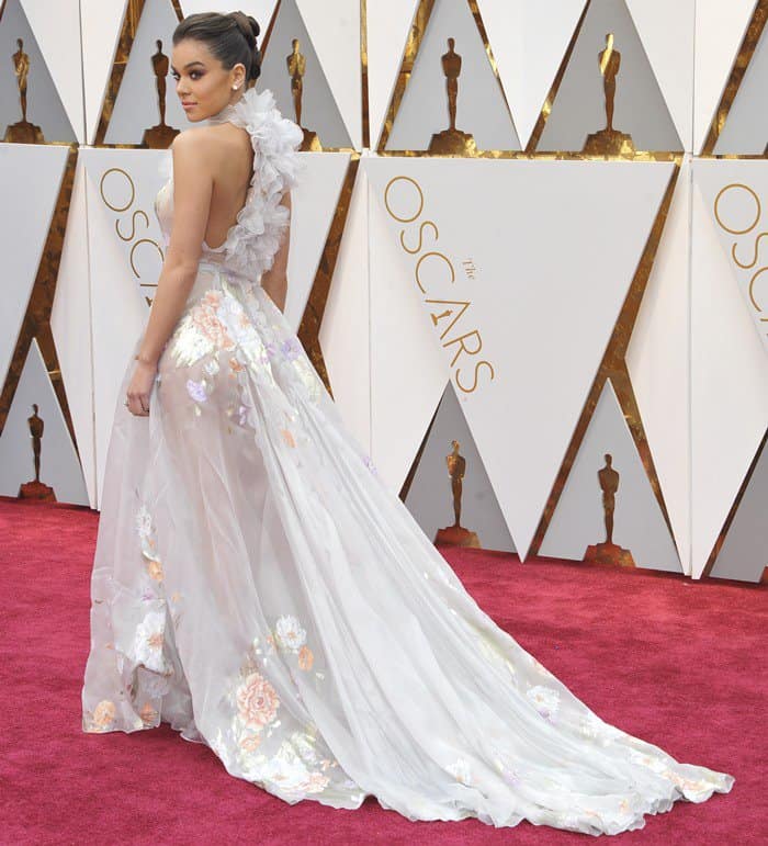 Hailee Steinfeld radiates elegance in a sheer Ralph Russo gown with cascading floral details and a dramatic train at the 2017 Oscars