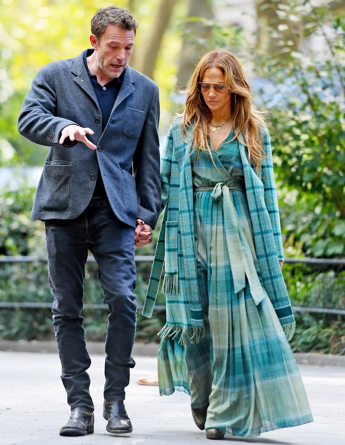 Jennifer Lopez and Ben Affleck stroll hand in hand through Madison Square Park, with J.Lo wearing a flowing green plaid dress and matching coat while Ben keeps it classic in a charcoal blazer and dark jeans