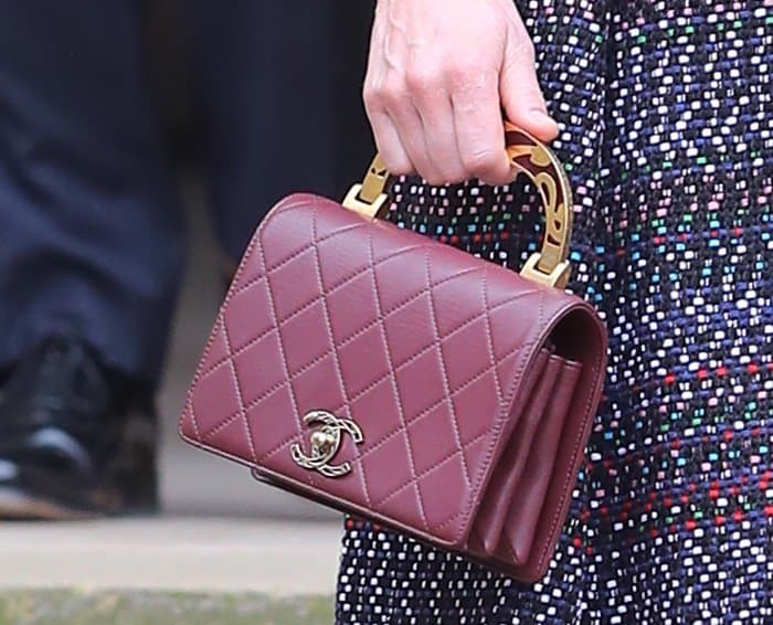 The bag is adorned with Chanel’s iconic interlocking CC logo in gold-tone metal on the front, paired with a turn-lock closure for security and style