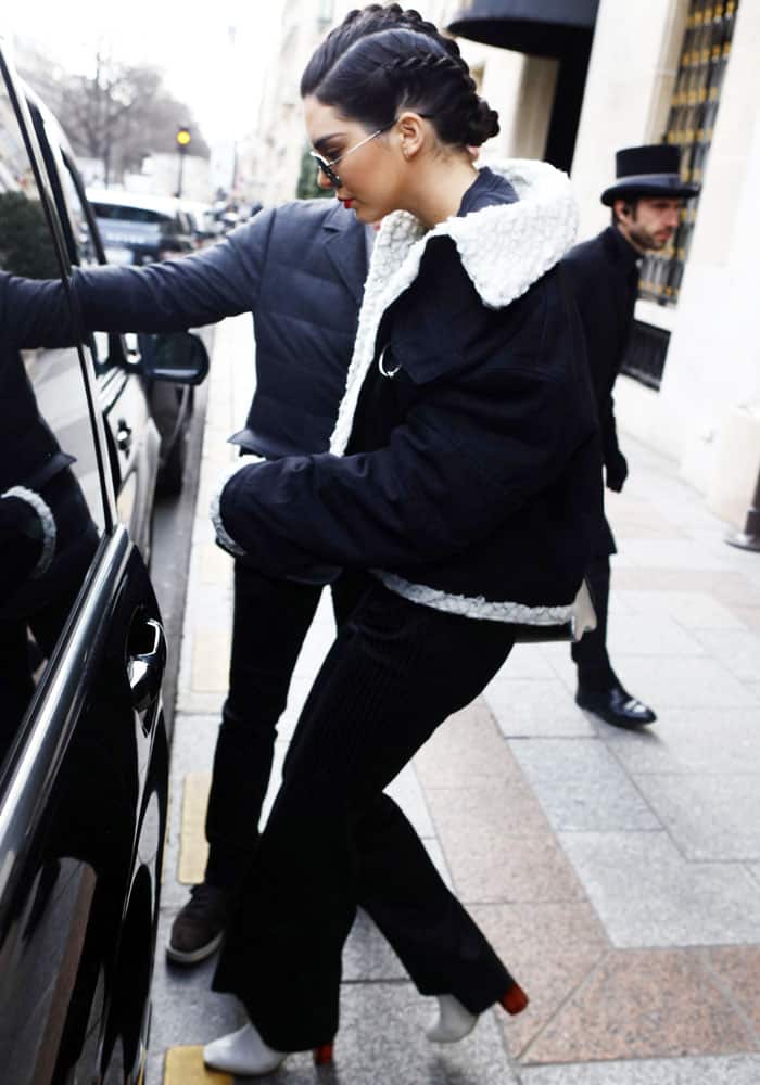 Stepping into her car in Paris, Kendall pairs wide-leg pinstripes with a shearling-trim Ambush jacket and her go-to white boots