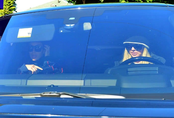 Khloé and Kim Kardashian are photographed through the windshield as they leave together, offering a candid glimpse of a low-key sister moment between errands