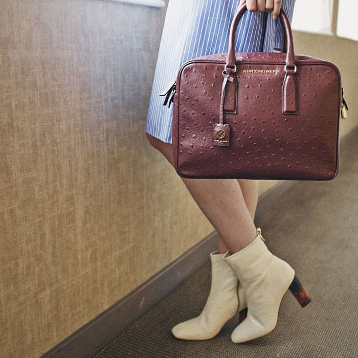 Kurt Geiger’s “Strut” boots in white leather pair effortlessly with a powder-blue skirt and burgundy ostrich-embossed satchel for a polished, modern finish