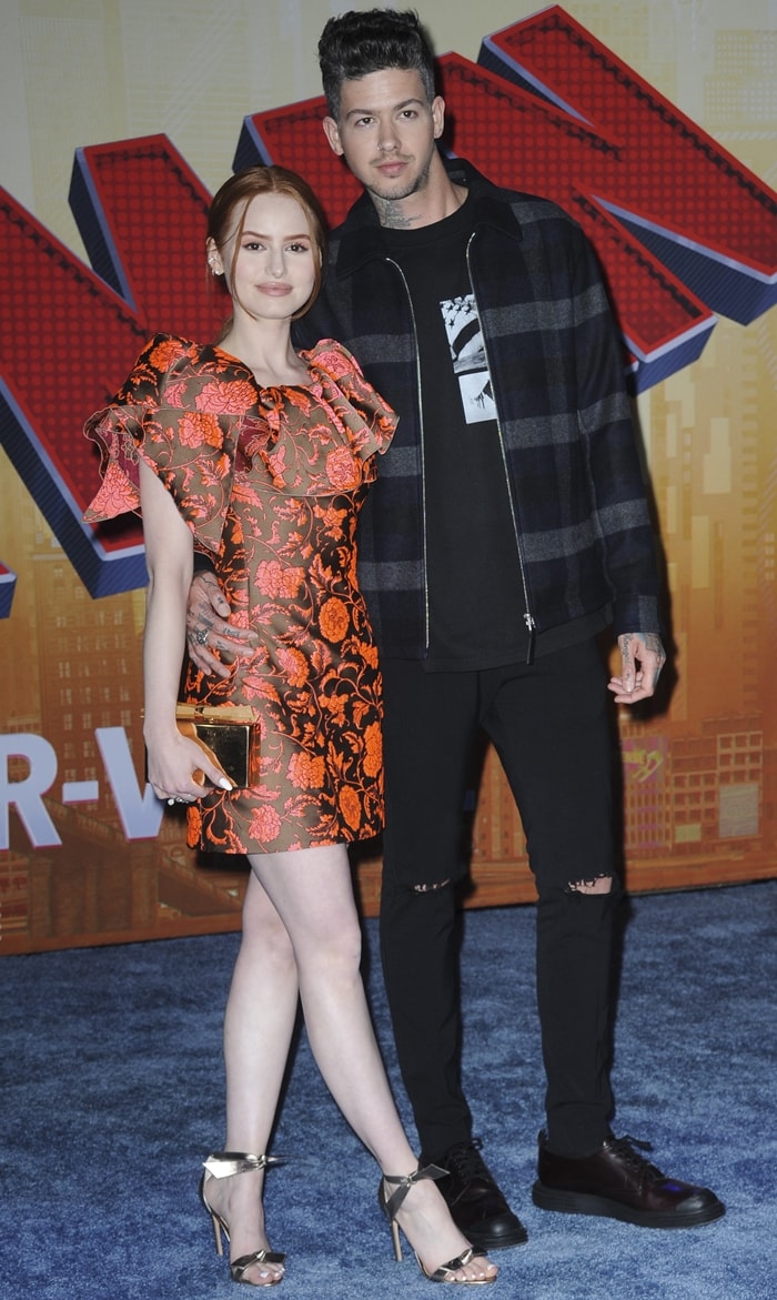 Madelaine Petsch styled a dramatic floral Paule Ka cocktail dress with metallic gold ankle-strap sandals while attending the Spider-Man: Into the Spider-Verse premiere alongside then-boyfriend Travis Mills in Westwood, California