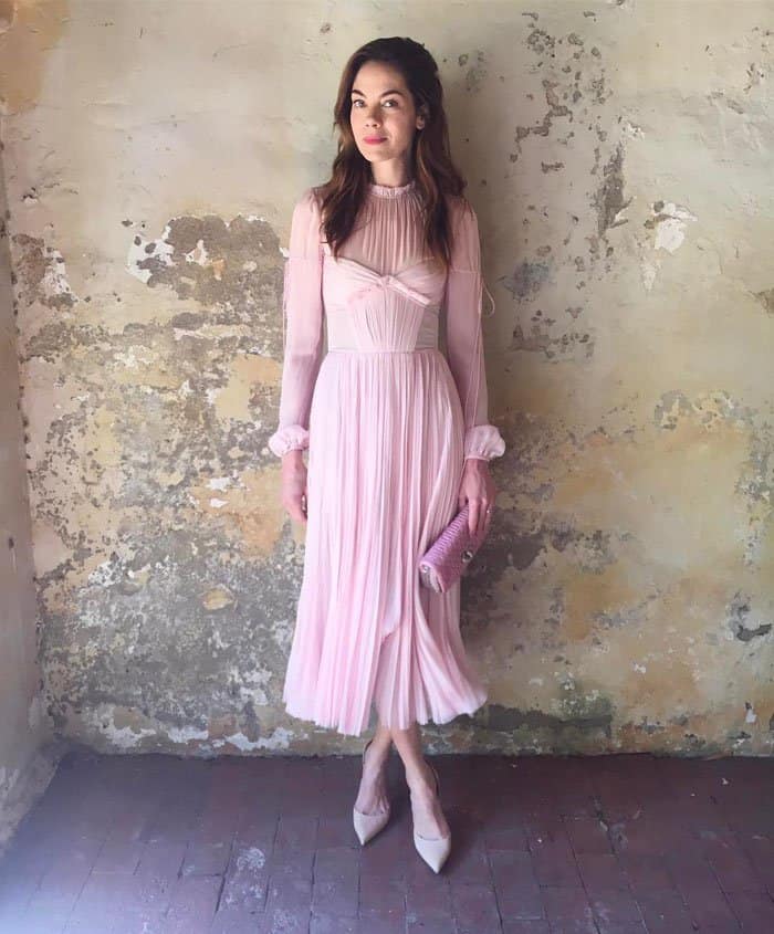 Michelle shares her ethereal pink ensemble on Instagram, showcasing a pleated J. Mendel dress, nude pumps that elongate her legs, and a textured Miu Miu clutch