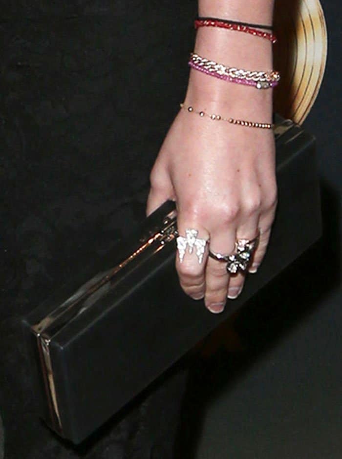 A perfect blend of sophistication and functionality, Rumer Willis elegantly clutches a sleek, rectangular Halston clutch, complementing her ensemble with its timeless design