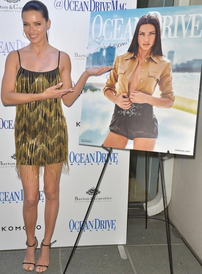 Adriana Lima proudly presents her Ocean Drive magazine cover at Komodo Lounge in Miami, dazzling in a black-and-gold Misha Collection mini dress
