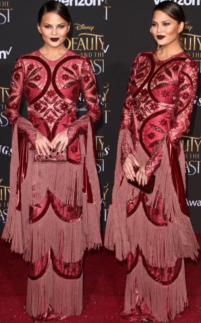 Chrissy Teigen dazzles in a bold Raisa Vanessa gown with intricate fringe and geometric embellishments at the 'Beauty and the Beast' Hollywood premiere