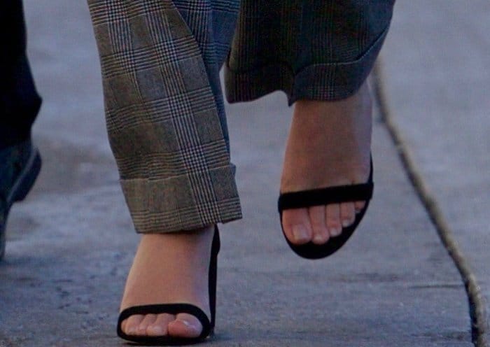 Emma Watson's sandals are minimalist black ankle-strap heels from SUSI Studio, specifically the "Hey Simone" style