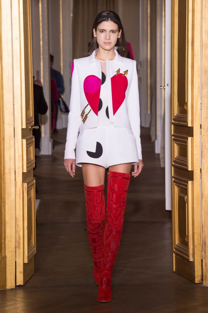 On the runway, the Schiaparelli Spring 2017 look pairs the same thigh-high boots with a matching heart-motif jacket, confirming their couture origins
