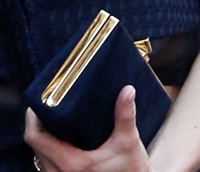 Anna Faris completes her look with a structured blue velvet clutch featuring gold trim
