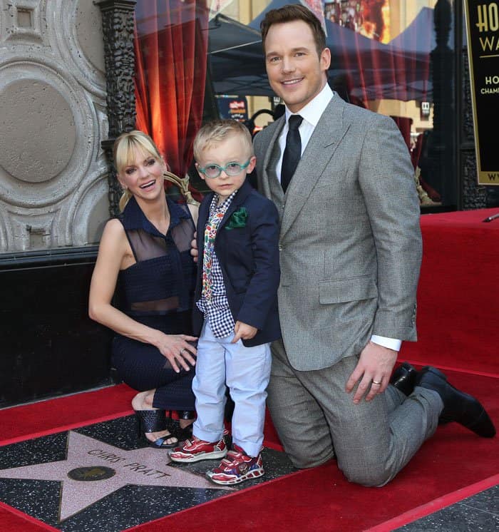 Anna Faris and Chris Pratt pose with their son Jack, who stole the spotlight in red patterned sneakers, light blue trousers, a gingham shirt, and a navy blazer with a green pocket square