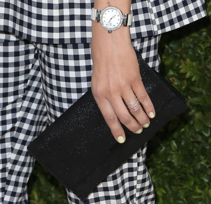 Camilla Belle's stylish accessories included a sleek silver watch, delicate rings, and a chic black clutch