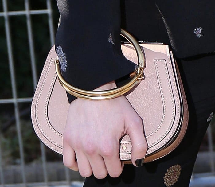 Emma carrying a blush-toned Chloé Nile medium purse, styled with its signature gold bracelet handle for a modern, sculptural finish