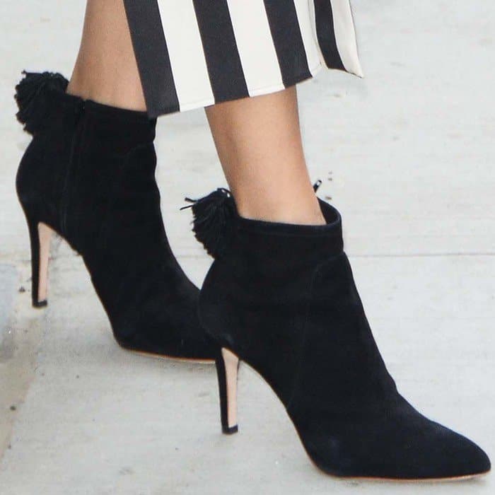 A closer look at Freida Pinto’s Loeffler Randall “Maryl” booties, designed in suede with playful back pompom detailing and a sleek stiletto heel