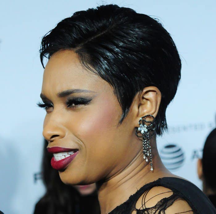 Jennifer Hudson reacts playfully on the red carpet, showing off her intricate, dangling Jacob Co. earrings that perfectly complement her edgy style