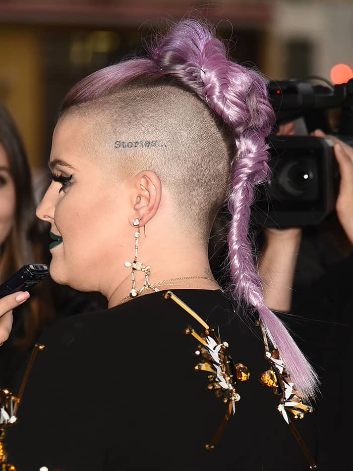 Kelly Osbourne shows off her "Stories..." tattoo located on the shaved side of her head above her left ear