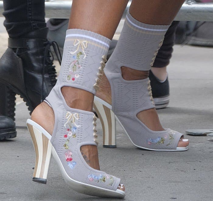 A close-up reveals the intricate embroidery and distinctive cutout design of Kelly Rowland's Fendi stretch-knit ankle boots
