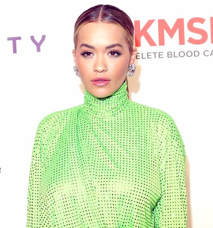 A close-up view highlights the singer's sophisticated makeup palette and the intricate, all-over crystal embellishments of the lime green fabric