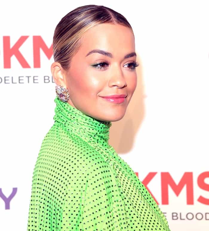 The star's polished beauty look featured a sleek center-parted ponytail that allowed her multi-colored statement earrings to take center stage