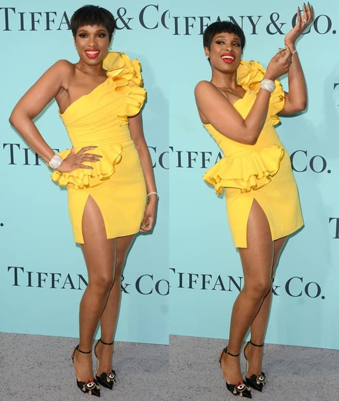 Jennifer Hudson turned heads at the Tiffany Blue Book Gala in a ruffled yellow DSquared2 mini dress, dazzling Tiffany Co. diamond jewelry, and black satin platform heels adorned with jeweled floral accents