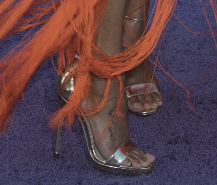 Zoe Saldaña's delicate foot tattoo and soft pink pedicure subtly peek through her metallic Jimmy Choo sandals