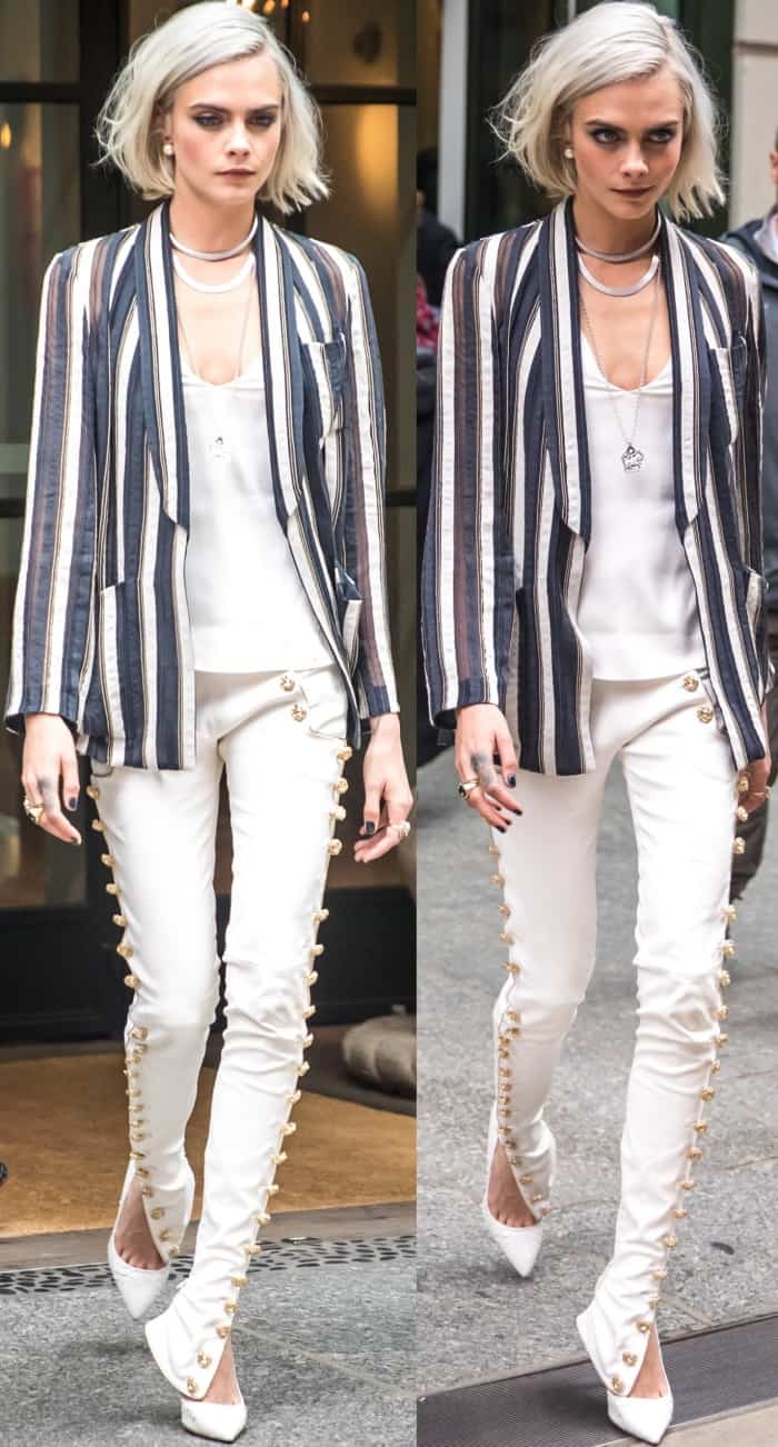 Cara Delevingne stuns in gold-buttoned Redemption pants, a striped Brunello Cucinelli blazer, and custom white Olgana Paris pumps while out in New York City