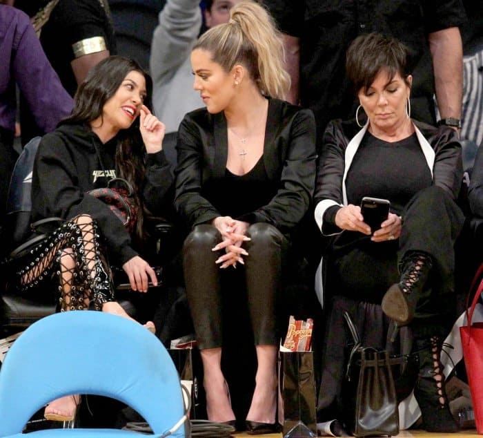 Kourtney Kardashian wearing Yeezy sandals, Khloé Kardashian wearing black pointy-toe pumps, and Kris Jenner wearing black lace-up booties at Lakers vs. Cavaliers basketball game