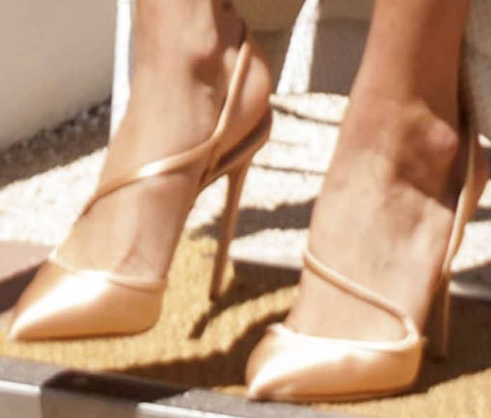 A closer view of Bella Hadid’s satin Olgana Paris heels, showing the brand’s signature criss-cross straps and pointed-toe silhouette
