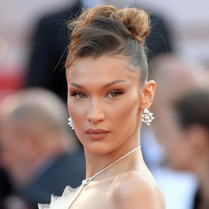 Close-up of Bella Hadid’s Cannes look, highlighting her radiant makeup, sculpted updo, and diamond Bulgari earrings that completed the ethereal ensemble