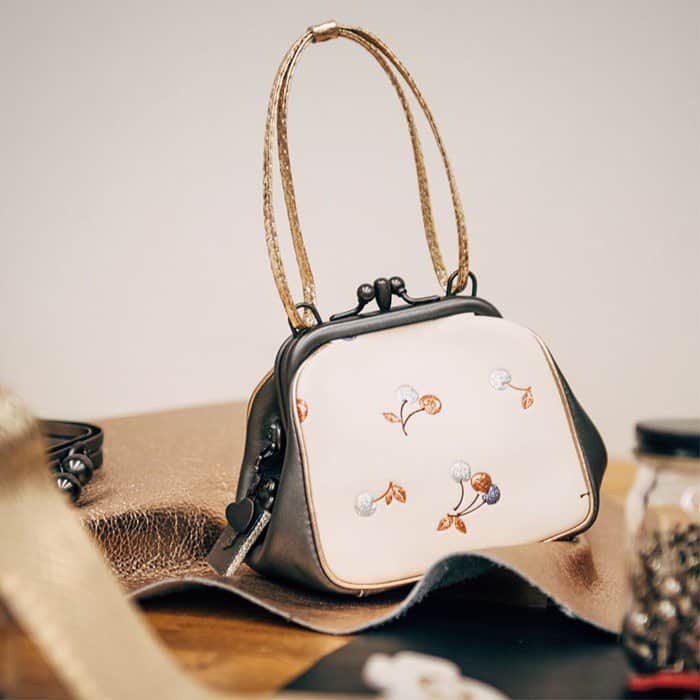 Coach cherry-printed 'Kisslock' frame bag crafted in champagne- and graphite-hued leather