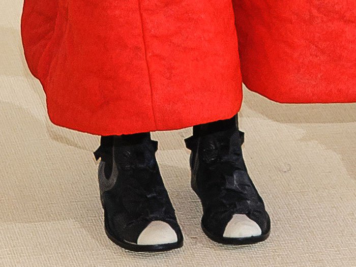 Close-up of the Nike x Comme des Garçons triple-bow boots on Helen Lasichanh