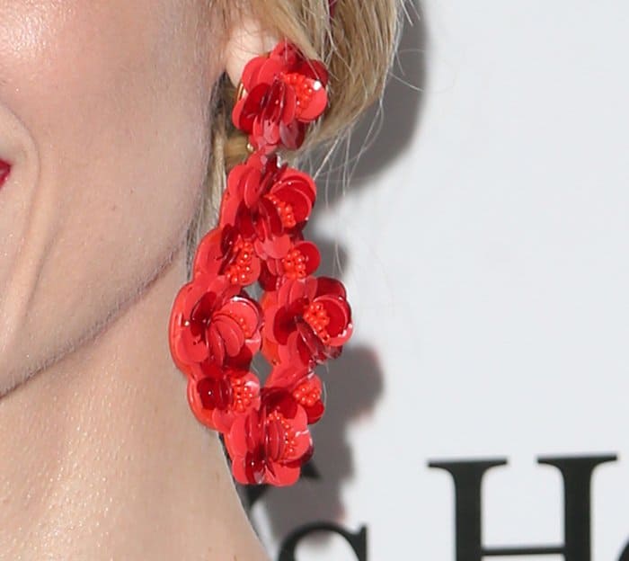 Jaime King completes her floral-themed look with oversized red statement earrings adorned with glossy, three-dimensional flower appliqués for a bold finishing touch