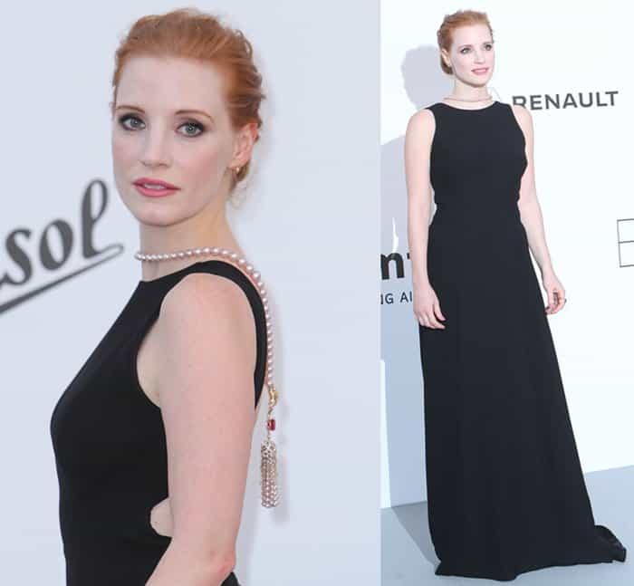 Jessica Chastain dazzles at the amfAR Gala in a sleek black Prada gown, accentuated by a stunning backward Piaget necklace featuring pearls and a ruby tassel
