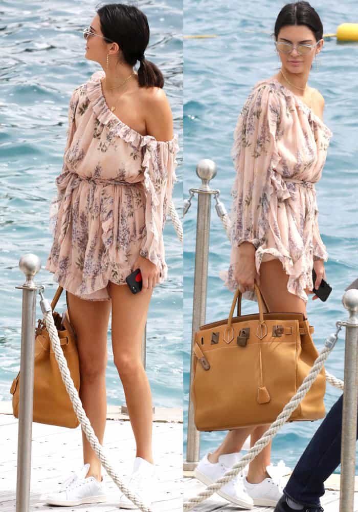 Kendall Jenner stuns in a floral Zimmermann romper, paired with white Adidas 'Stan Smith' sneakers and an oversized Hermès Birkin bag, while enjoying a boat day in Cannes