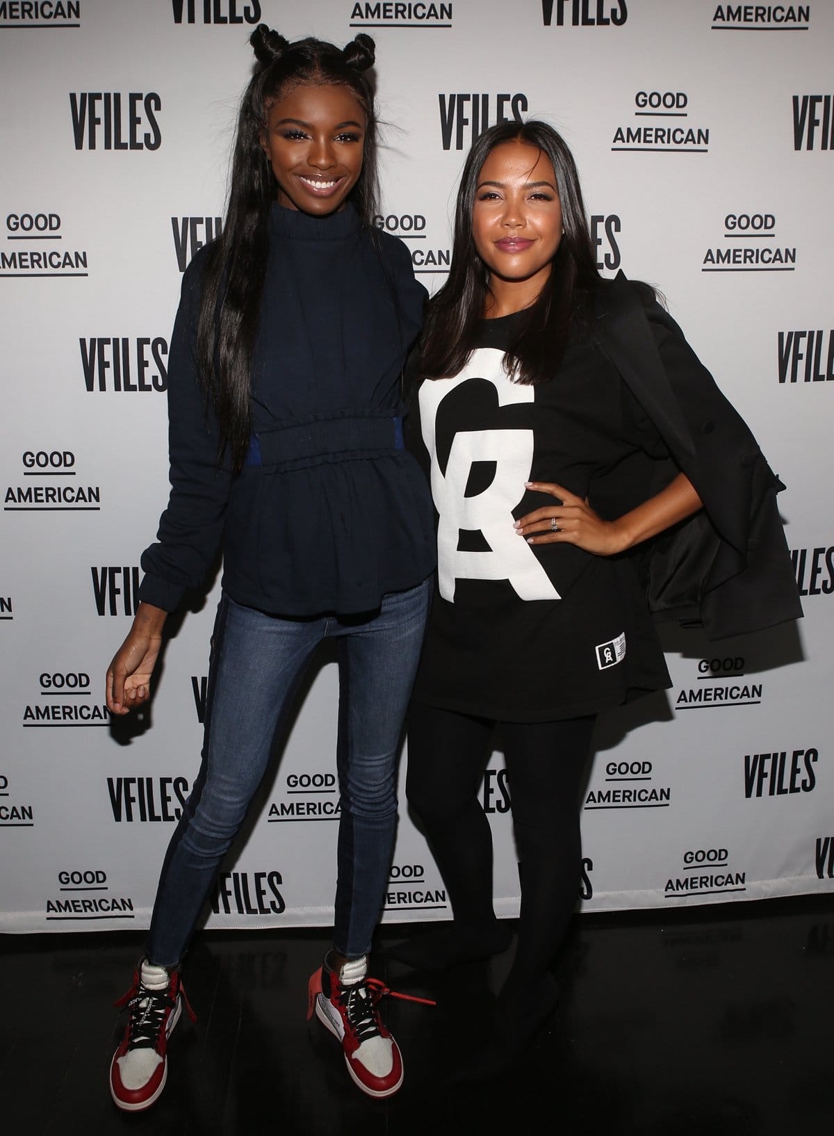 Founder and CEO of Good American Emma Grede (right) keeps it sleek in an oversized logo tee, black leggings, and blazer, while fashion designer Leomie Anderson (left) pairs a navy cinched-waist sweatshirt with skinny jeans and red-and-white Off-White x Nike sneakers at the Good American x VFILES event