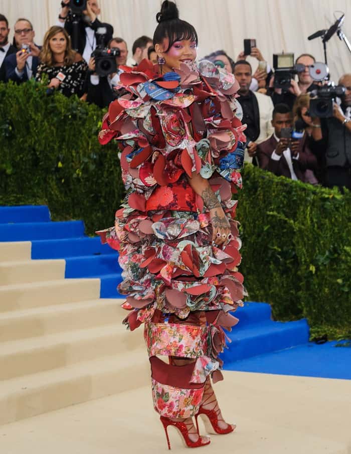 Rihanna turned heads in a Comme des Garçons Fall 2016 dress and eye-catching red strappy thigh-high sandals at the 2017 Met Gala