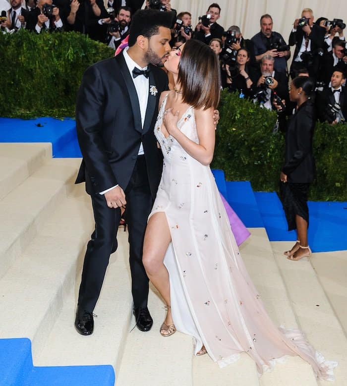 Selena Gomez pairs her sleek, straight lob with metallic ankle-strap heels and a custom Coach clutch engraved with “love yourself first,” completing her ethereal MET Gala look