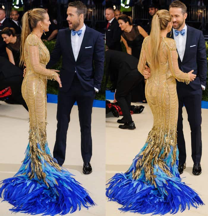 Blake Lively dazzled in a gold Atelier Versace gown with cascading blue feathered train, perfectly complementing Ryan Reynolds' classic navy tuxedo and matching bowtie at the 2017 Met Gala