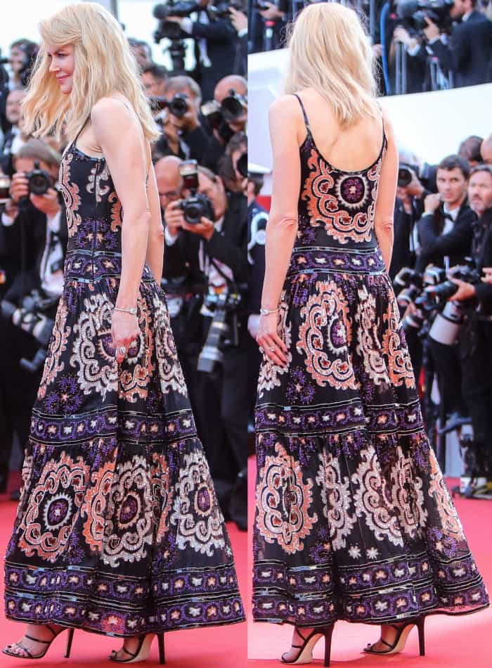 From the rear, the sweeping skirt gains structure and lift from delicate black sandals, allowing the ornate embroidery to flow without dragging the look down